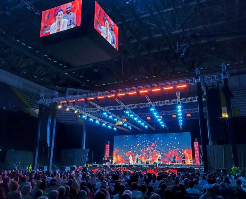 Arena concert stage with LED screens and overhead truss